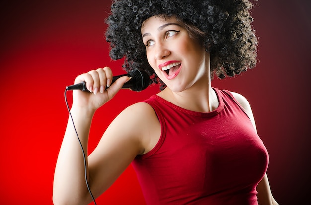 Vrouw met afro kapsel zingen in karaoke