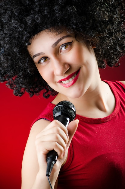 Vrouw met afro kapsel zingen in karaoke