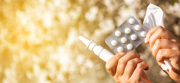 Vrouw met allergiepillen, medicijnen en neusspray tegen een soort allergie tijdens de lente hel