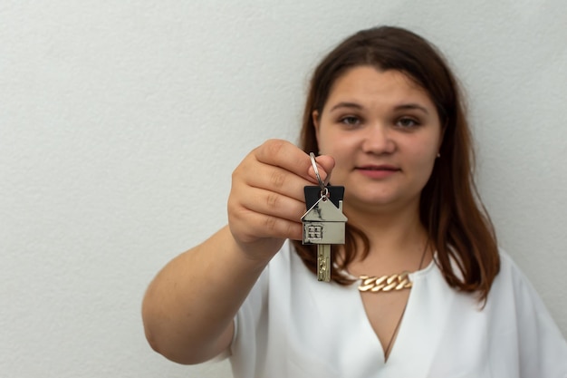 Vrouw met appartement sleutels op witte achtergrond.