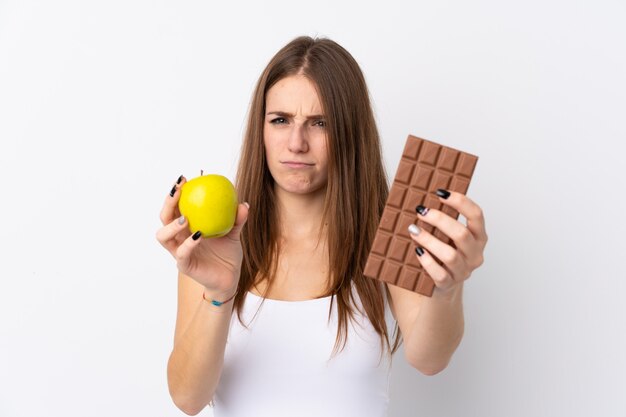 Vrouw met appel in de ene hand en chocolade in de andere