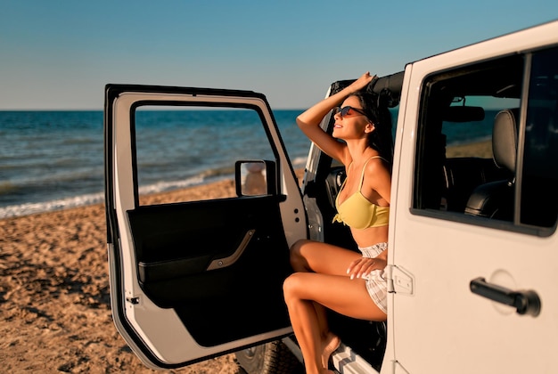 Vrouw met auto op strand