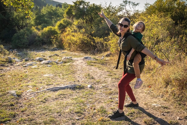 Vrouw met babydragende baby op een lange wandeling buiten