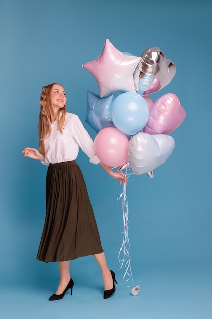 Vrouw met ballonnen op een blauwe ondergrond