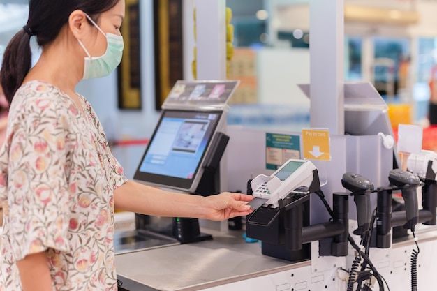 Vrouw met bankkaart eten betalen bij supermarkt selfcheckout