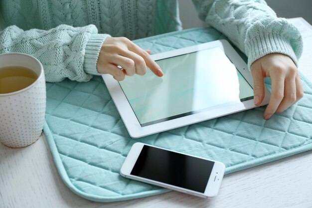 Vrouw met behulp van digitale tablet op tafel close-up