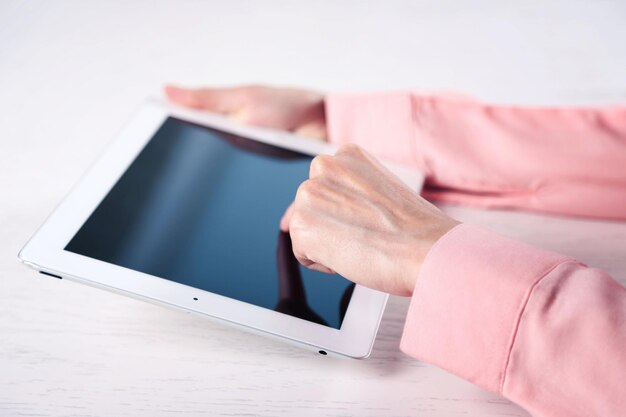 Vrouw met behulp van digitale tablet op tafel close-up