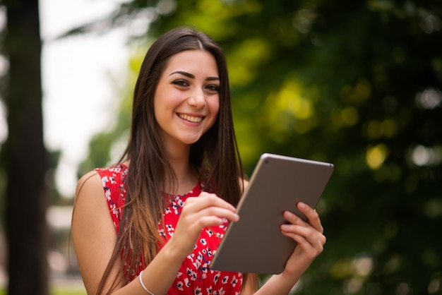 Vrouw met behulp van een digitale tablet in het park