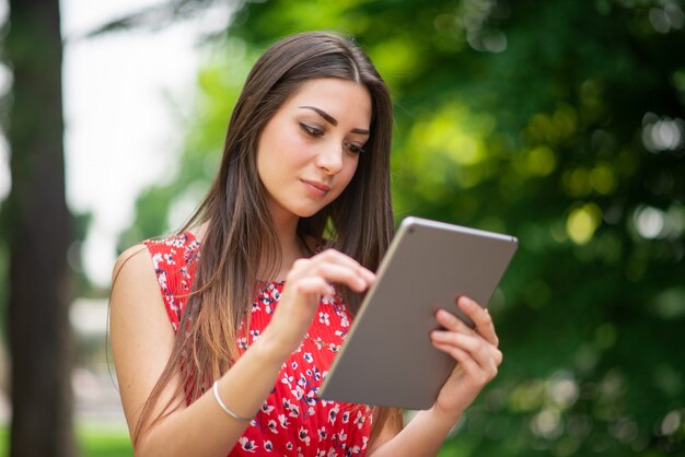 Vrouw met behulp van een digitale tablet in het park