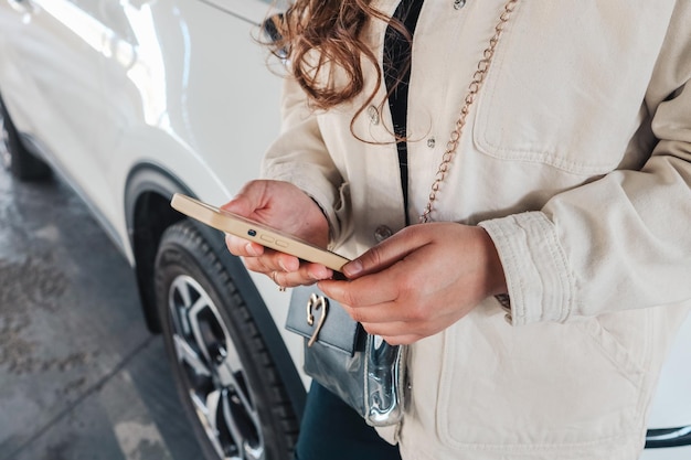 Vrouw met behulp van een telefoon voor een auto