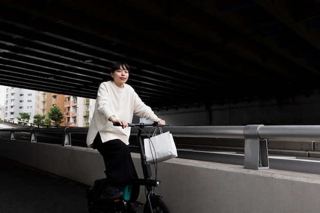 Foto vrouw met behulp van elektrische fiets in de stad