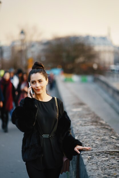 vrouw met behulp van haar mobiele telefoon tijdens een wandeling door de straten van Parijs Frankrijk