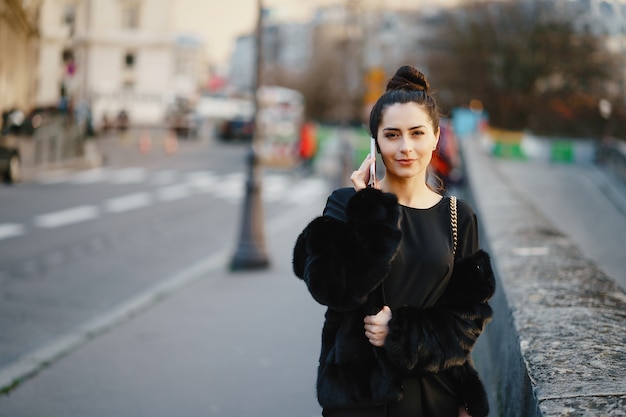 vrouw met behulp van haar mobiele telefoon tijdens een wandeling door de straten van Parijs Frankrijk