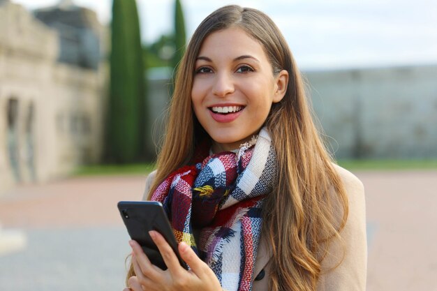 Vrouw met behulp van haar telefoon tijdens het wandelen in de stad