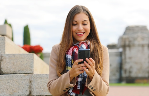 Vrouw met behulp van haar telefoon tijdens het wandelen in de stad