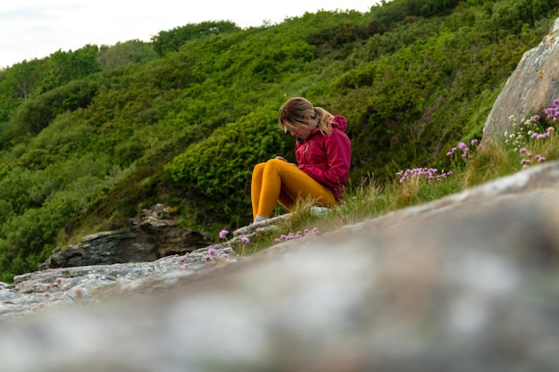 Vrouw met behulp van haar telefoon zittend op het strand