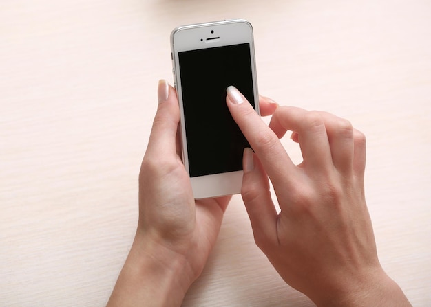 Vrouw met behulp van mobiele telefoon op de werkplek close-up