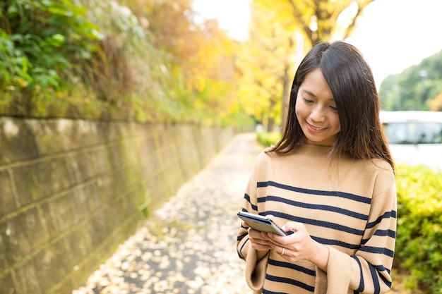 Vrouw met behulp van mobiele telefoon op outdoor park