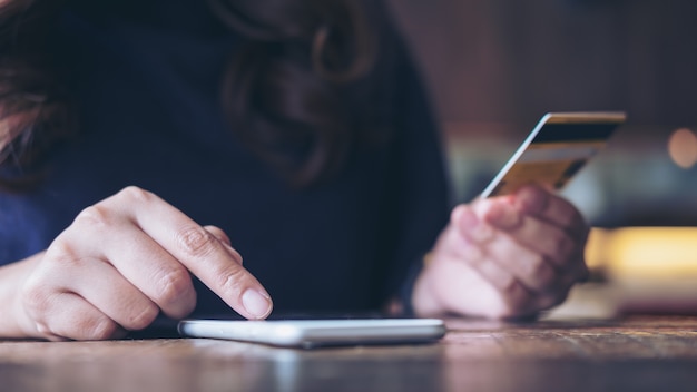 Vrouw met behulp van slimme telefoon en creditcard