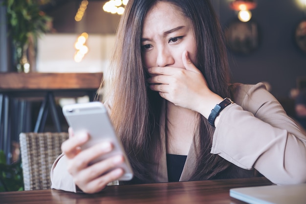 Vrouw met behulp van slimme telefoon met bang gevoel