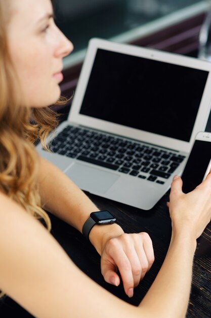 Vrouw met behulp van smartphone en laptop buitenshuis