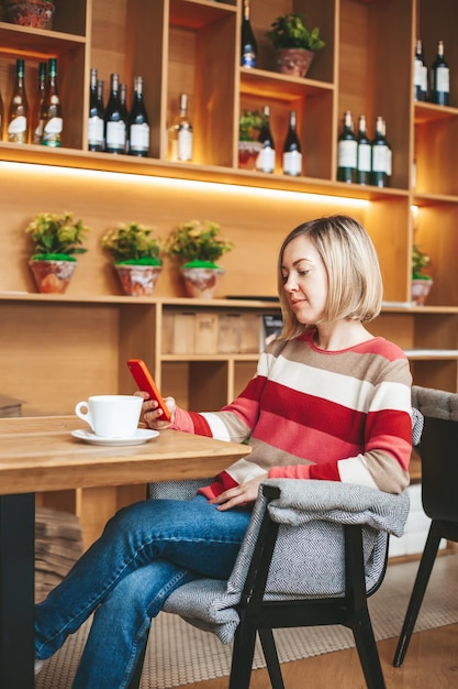 Vrouw met behulp van smartphone in café