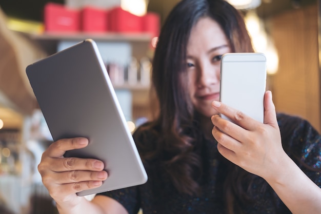 vrouw met behulp van tablet pc en telefoon