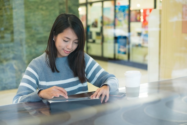 Vrouw met behulp van tablet pc in coffeeshop