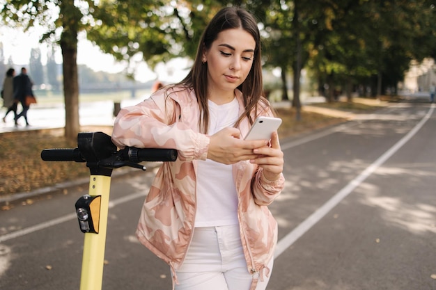Vrouw met behulp van telefoon tijdens de pauze befour rijden op escooter