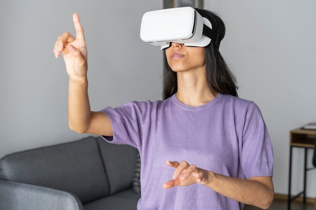 Vrouw met behulp van virtual reality headset thuis met laptop