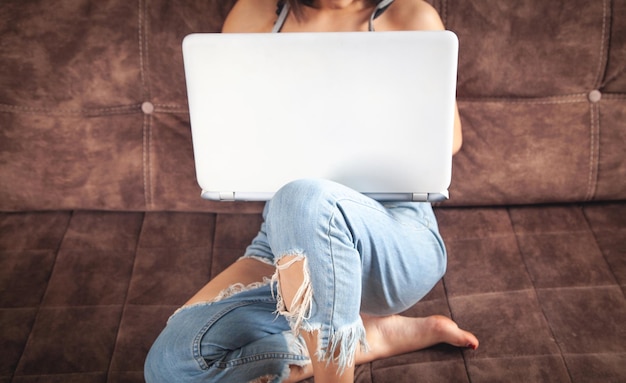 Vrouw met behulp van witte laptopcomputer thuis