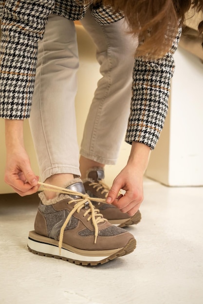 Vrouw met beige sneakers, leren schoenen, studio opname. Casual lifestyle concept foto