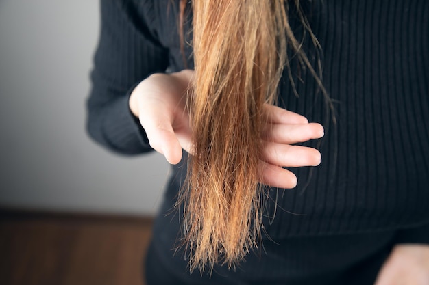 Vrouw met beschadigd haar de hand.