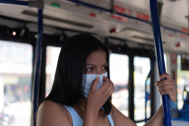 Vrouw met beschermend masker hoest in de bus