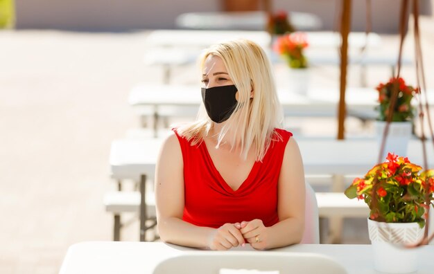 vrouw met beschermend masker op het zomerterras