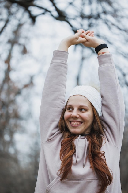 Foto vrouw met beugels die haar armen opheft