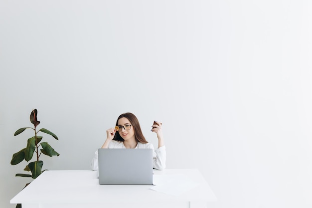 Vrouw met bitcoin zittend aan de tafel op grijze achtergrond