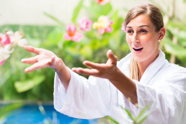 Foto vrouw met bloemen bij tropische poolside