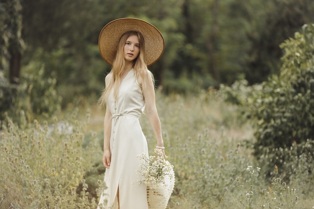 Vrouw met bloemen in de natuur in de zomer