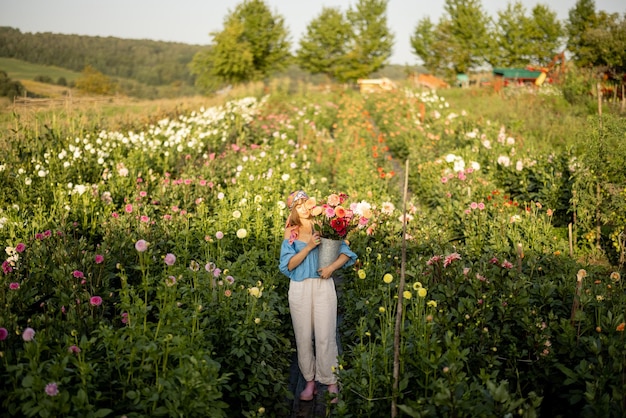 Vrouw met bloemen op dahlia boerderij buiten