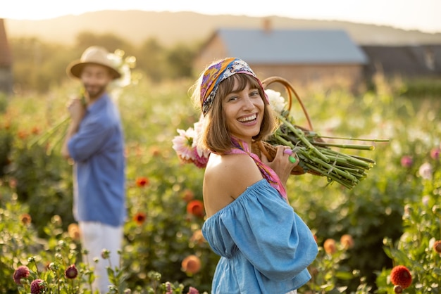 Vrouw met bloemen op dahlia boerderij buiten