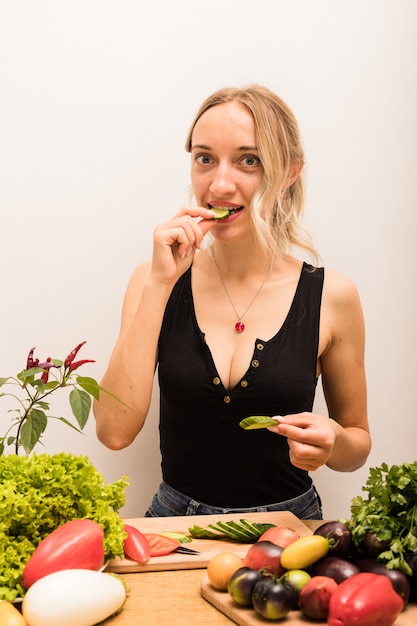 Foto vrouw met blond haar snijdt groenten op de keukentafel