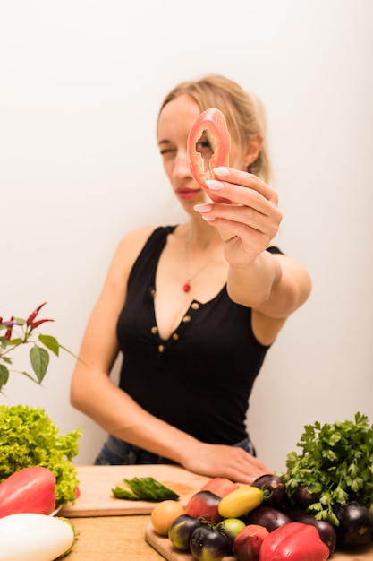 Vrouw met blond haar snijdt groenten op de keukentafel