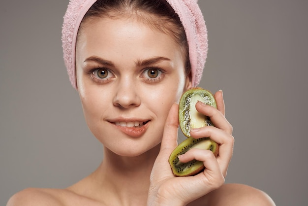 Vrouw met blote schouders Kiwi in haar handen natuurlijke cosmetica Hoge kwaliteit foto