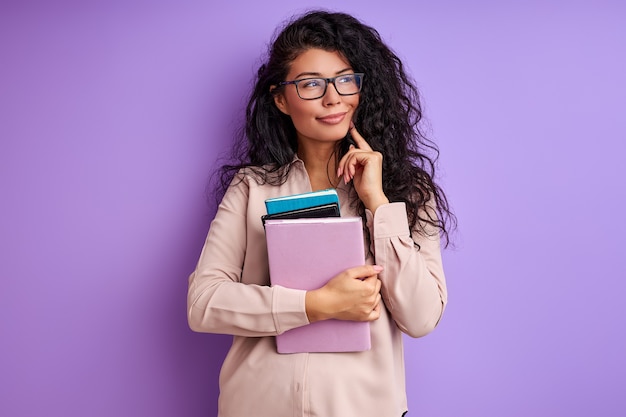 Vrouw met boeken geïsoleerd op paarse muur, liefde onderwijs, studeren. student vrouw in blouse, staan in contemplatie