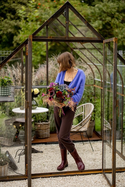 Vrouw met boeket bloemen in de tuin