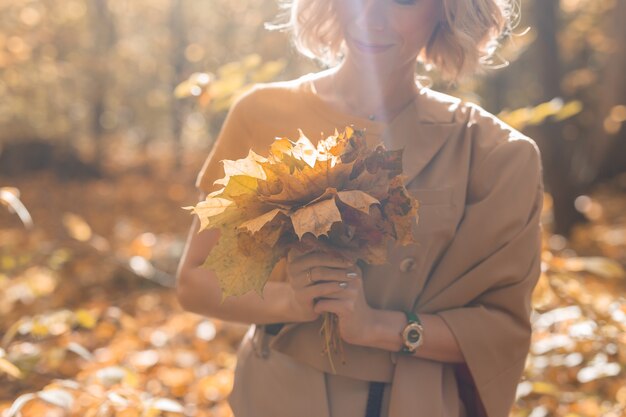 Vrouw met boeket herfst esdoorn bladeren seizoen en herfst concept