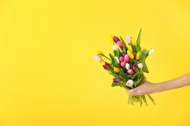 Vrouw met boeket tulpen op gekleurde achtergrond