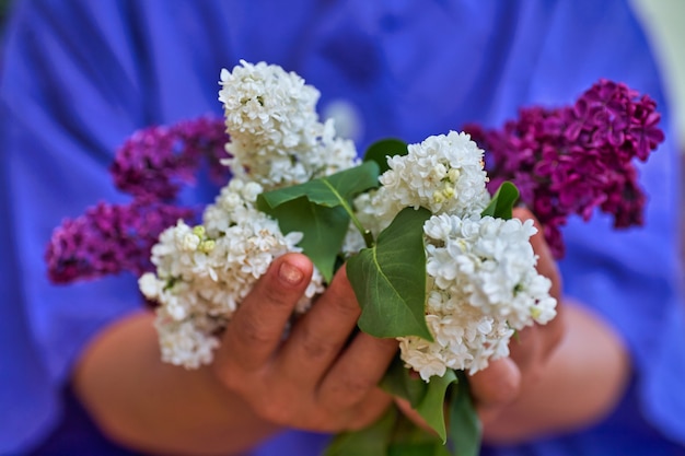 Vrouw met boeket van witte lillak in zijn hahd