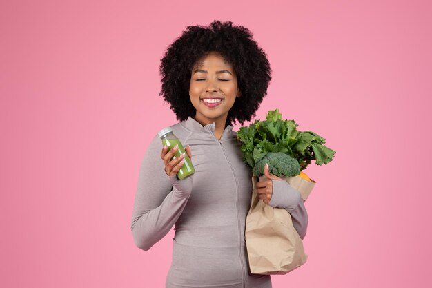 Vrouw met boodschappen en drinkend groen sap